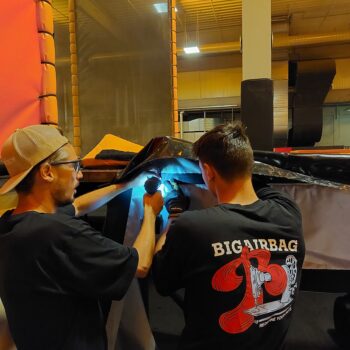 Techniciens BigAirBag effectuant une réparation sur place d’un airbag dans un parc de loisirs.
